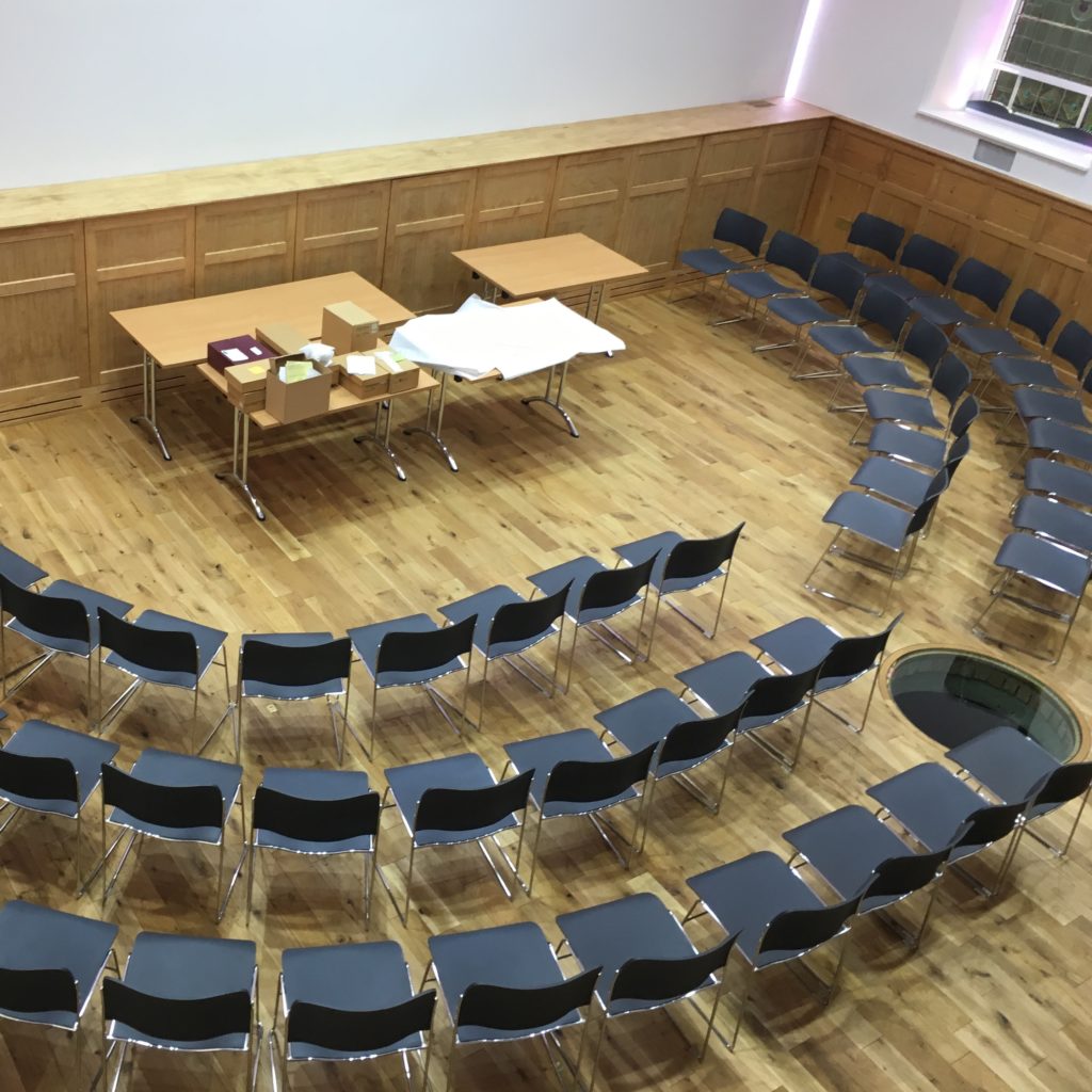 inside of rausing building set up with chairs in a concert style