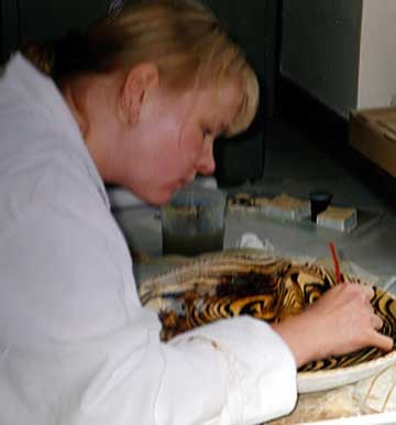 woman restoring museum collection item